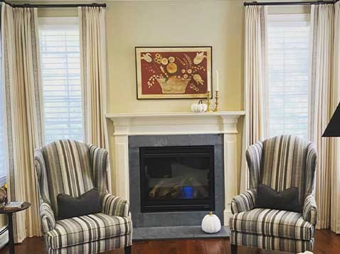 two black and white striped chairs with a fireplace in between